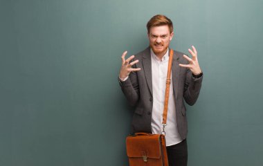 Genç kızıl saçlı iş adamı kızgın ve üzgün.