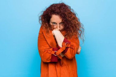 Genç, kızıl saçlı, zarif bir kadın. Düşük ateş ya da hastalık yüzünden soğuyor..