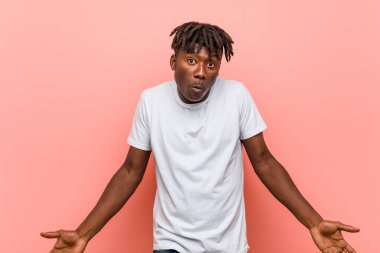 Genç Afrikalı siyah adam omuz silker ve gözleri açık kalır..