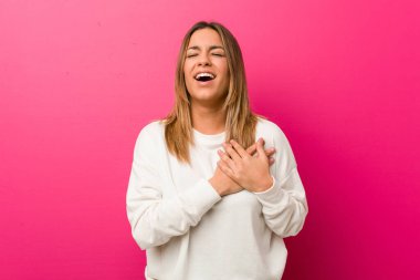 Genç otantik karizmatik gerçek insanlar kadın bir duvara karşı gülerek kalp, mutluluk kavramı ellerini tutarak.