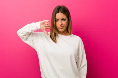 Genç otantik karizmatik gerçek insanlar kadın bir duvara karşı bir nefret jest gösteren, başparmak aşağı. Anlaşmazlık kavramı.