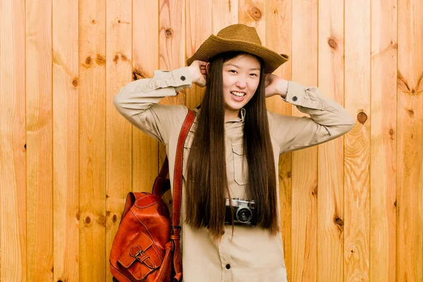 年轻的中国女旅行家高兴地把手放在头上笑着 幸福的概念 — 图库照片