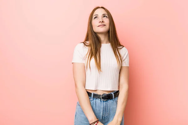 Junge Rothaarige Ingwerfrau Vor Einer Rosa Wand Die Davon Träumt — Stockfoto