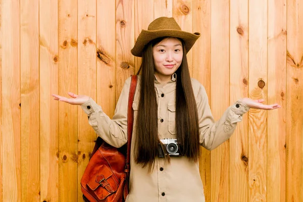年轻的中国女旅行家在提问时的怀疑和耸了耸肩 — 图库照片