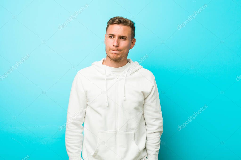Young caucasian sport man confused, feels doubtful and unsure.