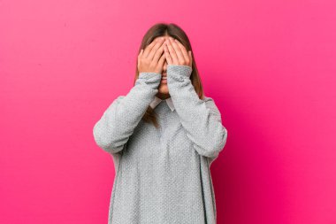 Genç, otantik, karizmatik bir kadın. Duvara yaslanmış gerçek bir kadın. Gözleri ellerle kaplıyor..