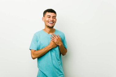 Genç İspanyol adam kalp, mutluluk kavramı ellerini tutarak gülüyor.