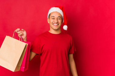 Genç adam Noel günü bir hediye tutuyor.