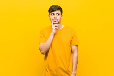 Genç İspanyol rahat adam şüpheli ve şüpheci ifade ile yan bakıyor.