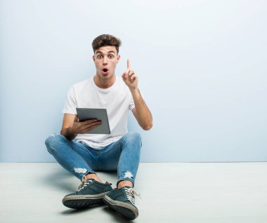 Elinde tablet tutan genç bir adamın harika bir fikri var, yaratıcılık kavramı..