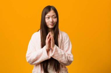 Pijamalı genç Çinli kadın bir plan yapıyor, bir fikir kuruyor..