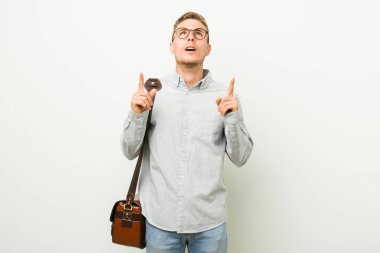 Kafkasyalı genç iş adamı ağzı açık bir şekilde üst tarafı işaret ediyor..