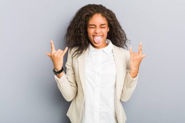 Genç Afrikalı Amerikalı iş kadını parmaklarıyla rock hareketi yapıyor.
