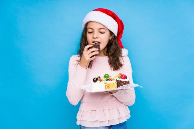 Küçük kız Noel 'i kutlamak için şeker tutuyor.