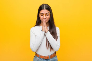 Sarı bir zemin üzerinde el ele tutuşan genç, güzel bir Arap kadın, kendine güveniyor..