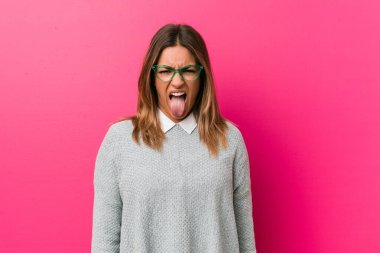 Bir duvara karşı genç otantik karizmatik gerçek insanlar kadın komik ve dostu dil dışarı yapışmasını.