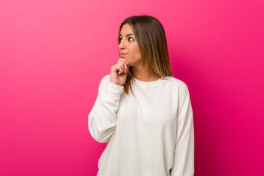 Şüpheli ve şüpheci ifade ile yana bakan bir duvara karşı Genç otantik karizmatik gerçek insanlar kadın.