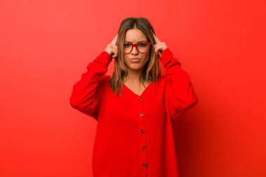 Bir görev odaklı bir duvara karşı genç otantik karizmatik gerçek insanlar kadın, baş işaret eden işaret parmakları tutmak.