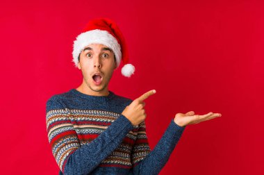 Genç adam Noel günü hoş bir sürpriz alıyor. Heyecanlı ve el kaldırıyor..