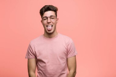 Genç, havalı, beyaz, komik ve dost canlısı bir adam dilini uzatıyor..