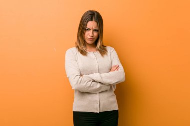 Genç otantik karizmatik gerçek insanlar kadın bir duvara karşı hoşnutsuzluk içinde yüz kaşlarını çatma, kollar katlanmış tutar.