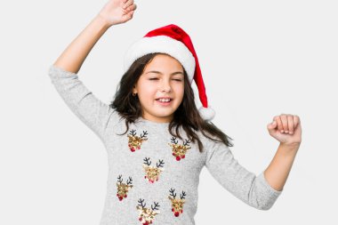 Küçük kız Noel 'i kutluyor özel bir günü, kollarını kaldırıyor enerjiyle.