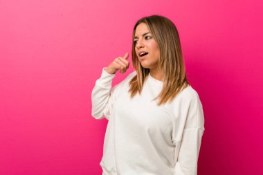 Parmakları ile bir cep telefonu arama jestgösteren bir duvara karşı Genç otantik karizmatik gerçek insanlar kadın.