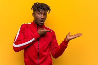 Genç fitness siyahi adam, elinde bir fotokopi odası tutarken heyecanlanıyor..