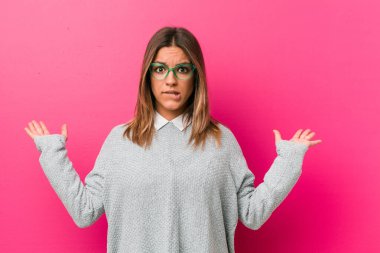 Bir duvara karşı genç otantik karizmatik gerçek insanlar kadın karışık ve şüpheli omuzsilkleme omuzlar bir kopyasını alanı tutmak için.