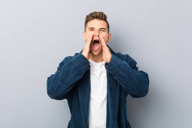 Genç, beyaz bir adam pijama giymiş ve bağırıyor..