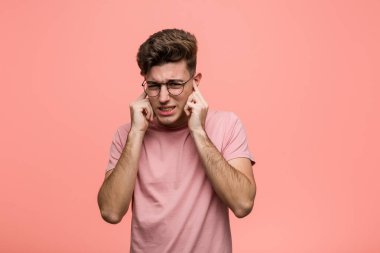 Kafkasyalı genç adam elleriyle kulaklarını kapatıyor..