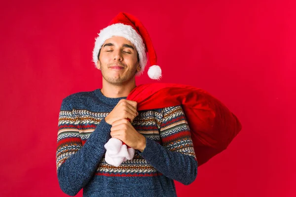 Ung man som håller en gåva på juldagen — Stockfoto
