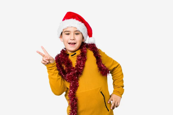 모자를 크리스마스를 축하하고 소년은 손가락으로 평화의 상징을 즐겁고 외따로 떨어져 — 스톡 사진