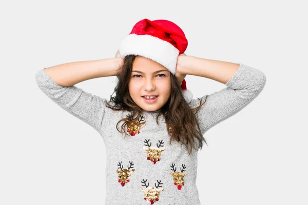 小女孩双手捂着耳朵庆祝圣诞节 尽量不要听到太大声的声音 — 图库照片