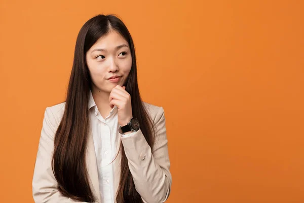 Young business chinese woman looking sideways with doubtful and skeptical expression.