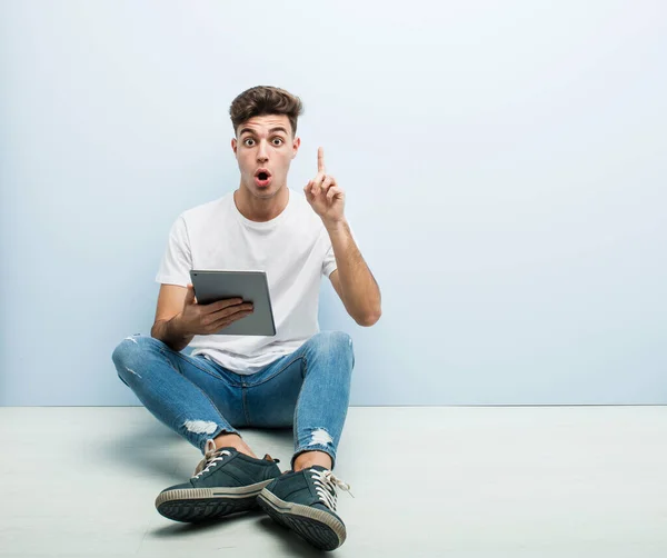 Joven Sosteniendo Una Tableta Sentada Interior Teniendo Una Gran Idea — Foto de Stock