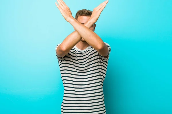 Jonge Blanke Man Tegen Een Blauwe Muur Met Twee Armen — Stockfoto