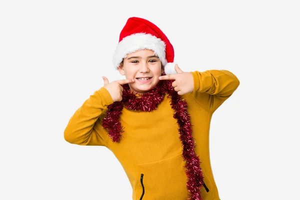 Niño Celebrando Día Navidad Con Sombrero Santa Sonrisas Aisladas Señalando —  Fotos de Stock