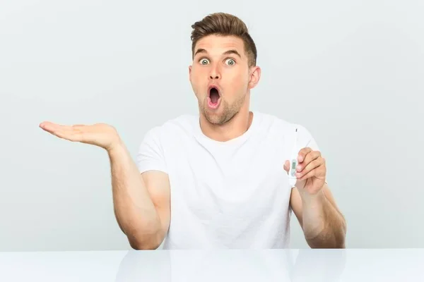 Young Handsome Man Holding Thermometer Impressed Holding Copy Space Palm — Stock Photo, Image