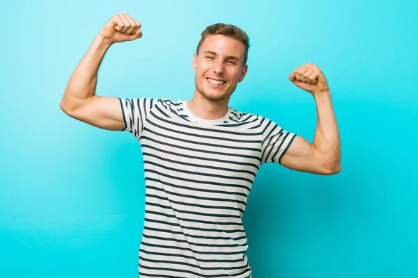 Giovane Uomo Caucasico Contro Muro Blu Che Mostra Gesto Forza — Foto Stock