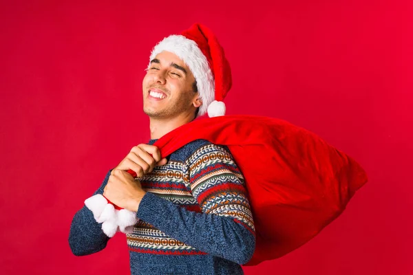 Young man holding a gift on christmas day — Stock Photo, Image