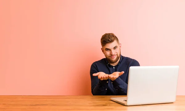 Young Man Working His Laptop Holding Something Palms Offering Camera — Stok fotoğraf