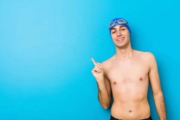 Mladý Plavec Vesele Usmívá Ukazováčkem Pryč — Stock fotografie