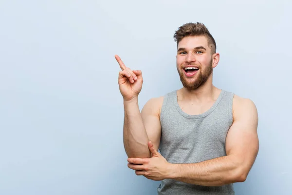 Young Handsome Fitness Man Smiling Cheerfully Pointing Forefinger Away — Stok fotoğraf