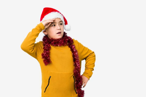 Mały Chłopiec Świętujący Boże Narodzenie Odosobnionym Kapeluszu Trzymający Rękę Czole — Zdjęcie stockowe