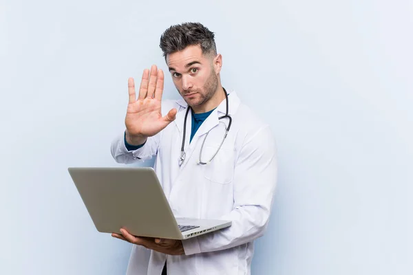 Caucasian Doctor Man Holding Laptop Standing Outstretched Hand Showing Stop — Stock Photo, Image