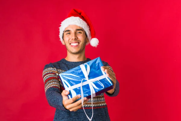 Młody człowiek trzyma prezent w Boże Narodzenie — Zdjęcie stockowe