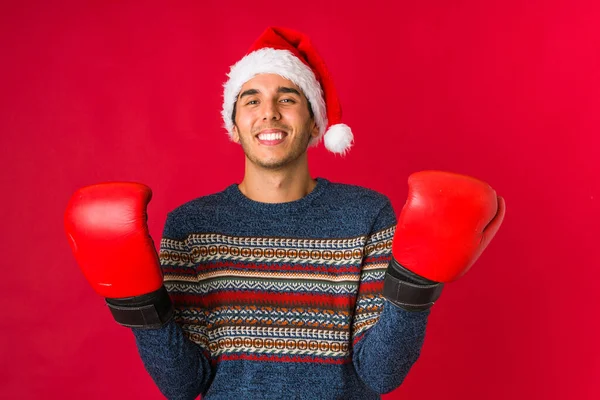 Young man holding a gift on christmas day — Stock Photo, Image
