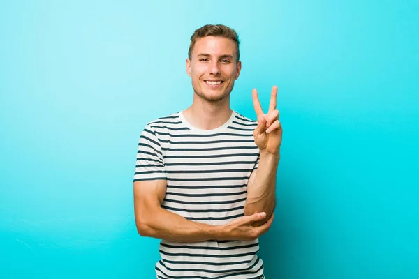 Jeune Homme Caucasien Contre Mur Bleu Montrant Numéro Deux Avec — Photo