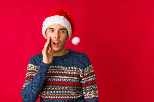 Молодий Чоловік Різдвяний День Вказує Великим Пальцем Подалі Сміючись Безтурботно — стокове фото